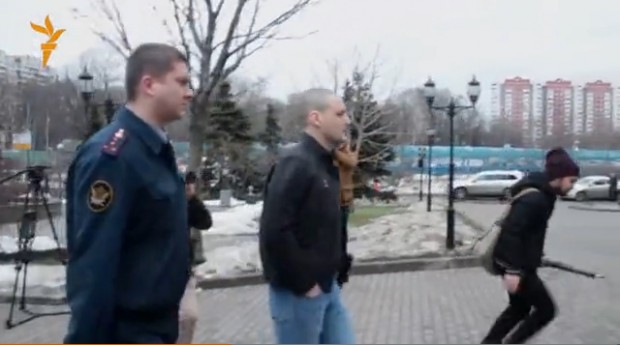 Udalstov being led by police to trial. From Radio Svoboda.